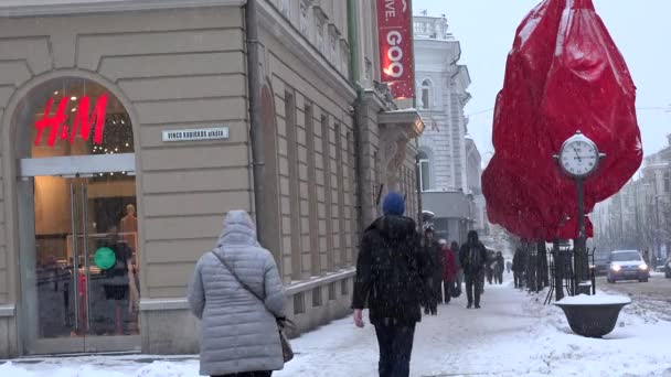Hm商店和人们走在大雪暴风雪。圣诞节装饰的城市场景 — 图库视频影像