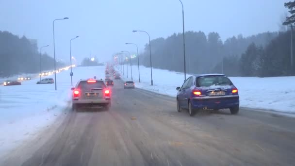 Авто ездить снегом покрытой дороги со светом в темноте. Камера в машине. 4K — стоковое видео