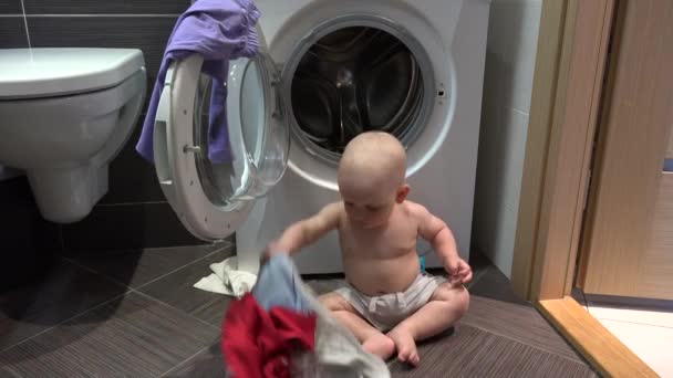 Niño malvado haciendo lío con la lavandería en el baño — Vídeos de Stock