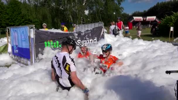 Pessoas felizes se divertem em espuma artificial após competição esportiva . — Vídeo de Stock