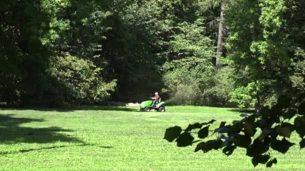 Park robotnik jeździ traktor koszenia trawnika rośnie w powietrzu. 4K — Wideo stockowe