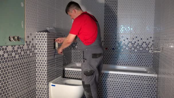 Werknemer trekken water uit pijp van toilet doorspoelen mechanisme — Stockvideo