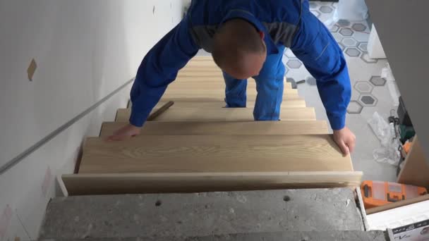 Любительский работник установить дубовую лестницу шаг в лестницу и измерить с помощью метра инструмента — стоковое видео