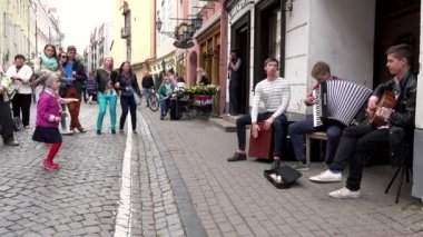 Genç çocuklar seyircilere karşı müzik aletleri çalarlar. Panorama.