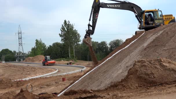 Excavadora máquina nivelación colina suelo y rodillo trabajando en la construcción de carreteras — Vídeos de Stock
