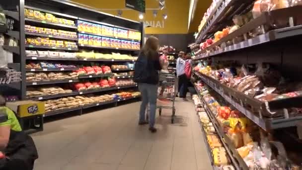 Vrouw met dochter meisje in kar winkelen brood in bakkerij afdeling — Stockvideo
