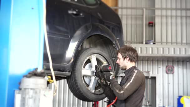 Auto mechanic strengthen wheel with an impact wrench. — Stock Video