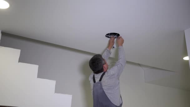 Man connect and install round LED light panel into plasterboard ceiling — Stock Video