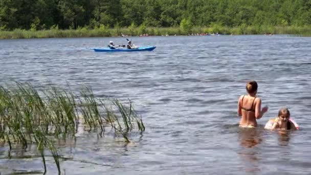 Ludzie odświeżyć w zimnej wody jeziora i wioślarstwo z kajakami. — Wideo stockowe