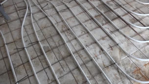 Трубы системы подогрева пола на полу перед укладкой бетона — стоковое видео