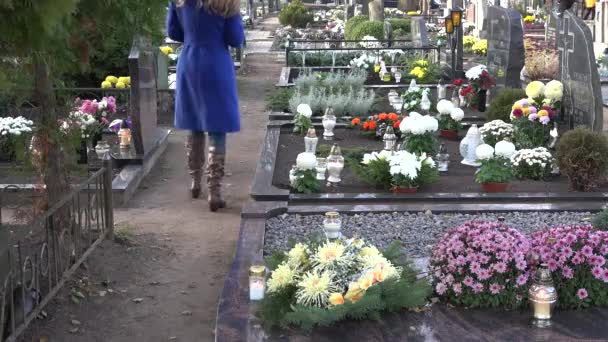 Mujer poner vela en marido padre tumba en el cementerio. 4K — Vídeo de stock