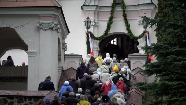 Personas católicas en las escaleras a la entrada de la iglesia — Vídeos de Stock