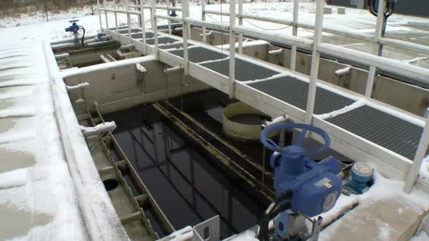 Blue big stopcock valve in water treatment plant and dirty liquid in aerotanks — Stock Video