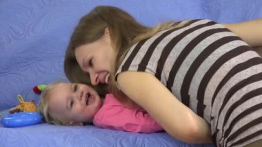 mutlu anne kanepe kapalı tatlı bebek kızı gıdıklamak. 4k