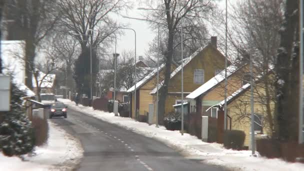 Landelijke Dorpshuizen en auto's die in de winter door straat rijden — Stockvideo