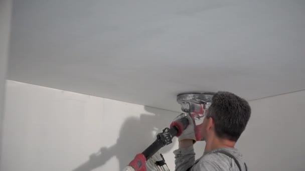 Amateur man polishing home ceiling with sanding grinder machine — Stock Video