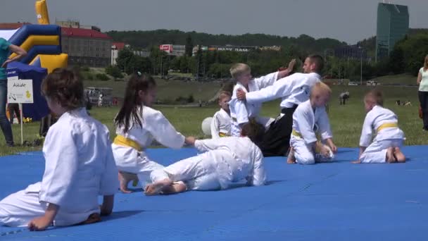 Jonge kinderen met een martial trainer leren aikido vaardigheden in het stadscentrum. 4k — Stockvideo