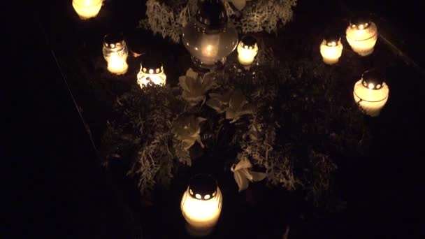 Bougies colorées sur le cimetière à la Toussaint le soir. 4K — Video