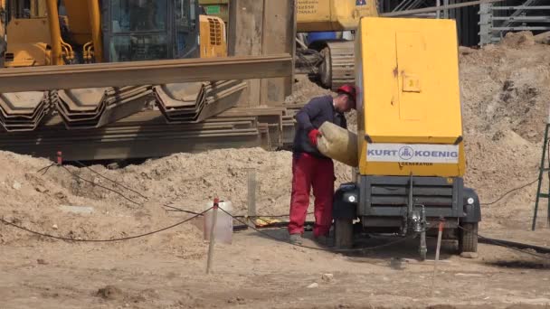 Trabalhador homem derramando combustível diesel em gerador e obras de construção de rodovias — Vídeo de Stock