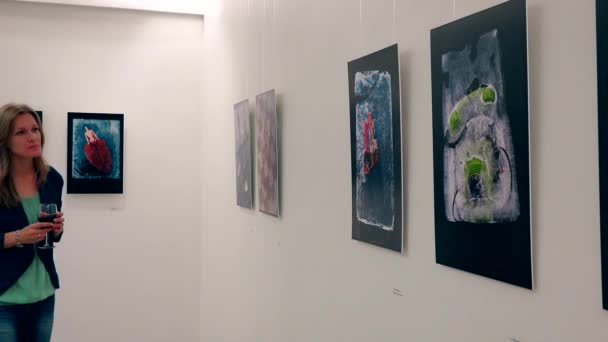 Mujer bonita con copa de vino disfrutar de la fotografía exposición de arte — Vídeos de Stock