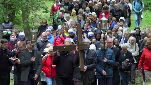 Muchas personas participan en la procesión de adoración religiosa llevando cruz — Vídeo de stock