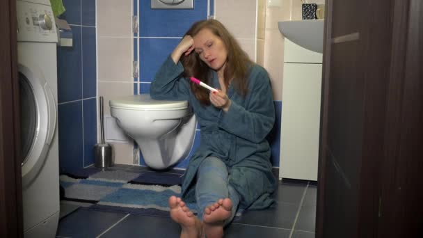 Unhappy woman with pregnancy test in bathroom. Positive negative result concept — Stock Video