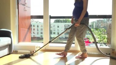 Ahşap zemin vakumlama genç hamile kadın