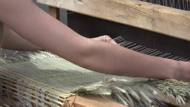 Woman hands weave carpet mat with retro handcraft loom in outdoor fair. 4K — Stock Video