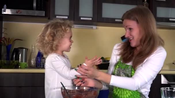 Άτακτος μητέρα και χαριτωμένο κόρη με σοκολάτα βρώμικα πρόσωπα στην κουζίνα — Αρχείο Βίντεο