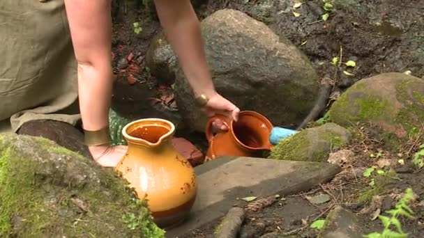 L'eau saine versant dans la cruche de pot d'argile — Video