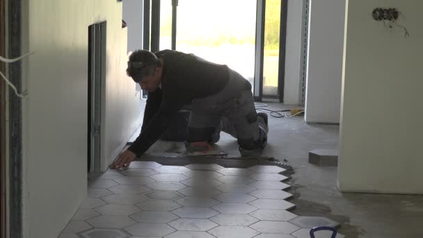 Carrelage de construction homme aligner carreaux de sol à la finition nouvel appartement — Video