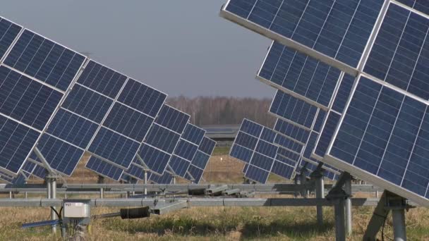 Paneles solares granja y coches van en segundo plano — Vídeo de stock