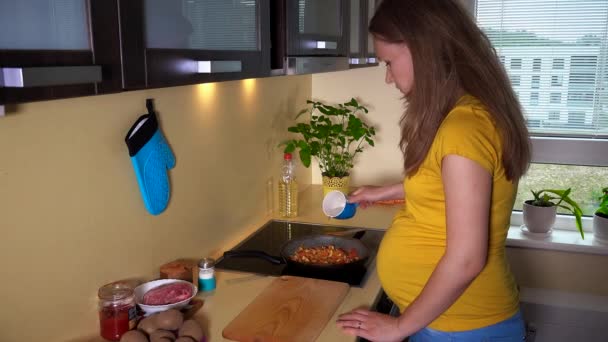 Mulher com barriga grande preparar o jantar na cozinha — Vídeo de Stock