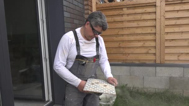 熟练的人使用角磨机在瓷砖上切孔 — 图库视频影像
