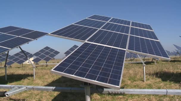Солнечные батареи, вращающиеся от солнца на голубом фоне неба — стоковое видео