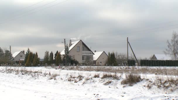 Dorfhaus aus Holz und Rauch steigen im Winter aus Schornstein auf — Stockvideo