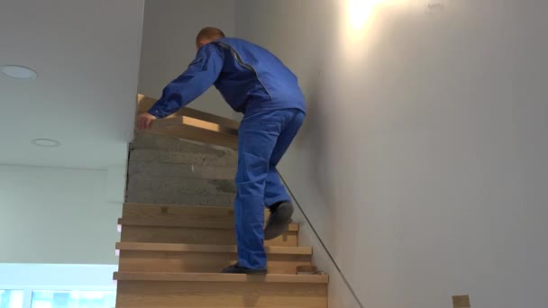 Homem carpinteiro qualificado instalar escadas de carvalho em novo apartamento — Vídeo de Stock