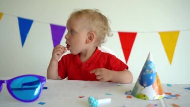 Küçük çocuk bir sopa üzerinde tatlı bir şeker berbat. Doğum günü partisinden sonra. Gimbal atış