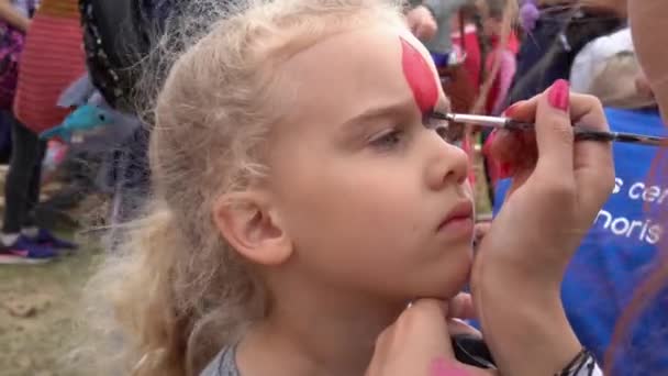 Pintura rosto de pequena menina bonito com cabelo encaracolado loiro. Movimento de Gimbal — Vídeo de Stock