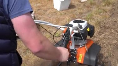 Güçlü adam elleri çiftlik evi bahçesinde pulluk üzerinde petrol kültivatör ile çalışan