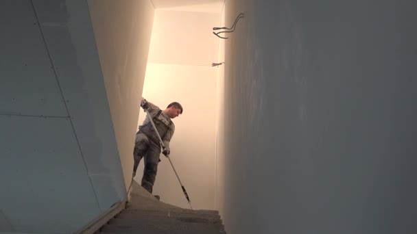 Professional painter man with roller tool painting ceiling of staircase — Stock Video