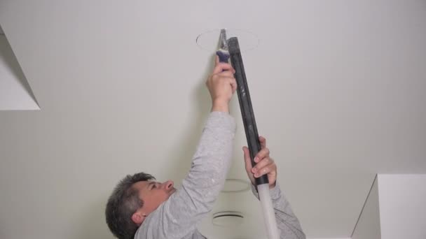 Handyman With Handsaw Making Drywall Ceiling Holes For Lighting Installation