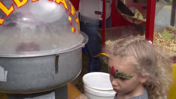 Alegre niña obtener su algodón caramelo candyfloss y caminar con sonrisa en la cara — Vídeo de stock