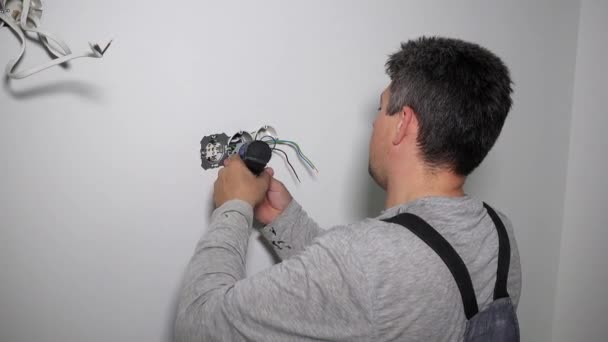 Electrician with screwdriver setting up outlet — Stock Video