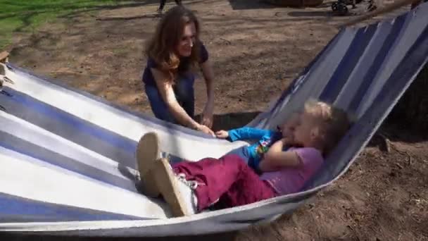 Liebende Mutter schwingt Sohn und Tochter auf Hängematte liegend. Gimbale Bewegung — Stockvideo