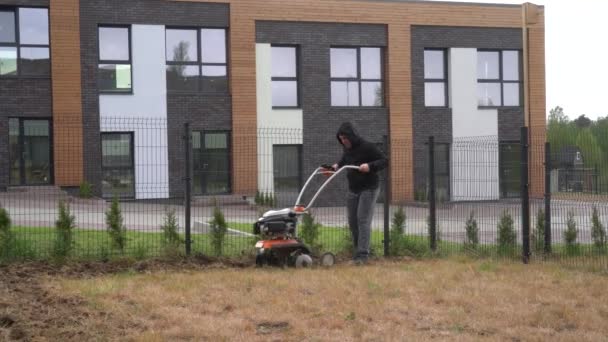 Hombre trabajando en el jardín con la máquina de timón. Cultivado, cultivador. Movimiento del cardán — Vídeos de Stock