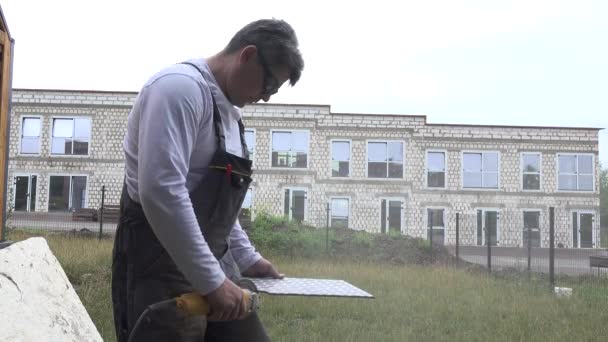 Craftsman cut wall tile with portable angle grinder — Stock Video