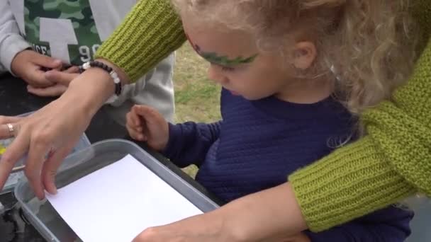 Excited daughter girl with mother make ebru painting on water. Gimbal motion — Stock Video