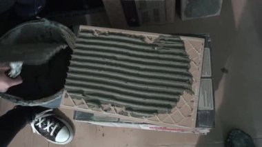 Spatulalı eller duvar kiremit yüzeyine yapıştırıcı tutkal betonu koydu