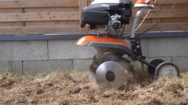 işçi ev bahçesinde yürüyüş traktörü ile toprak gevşetimi. Gimbal hareket closeup